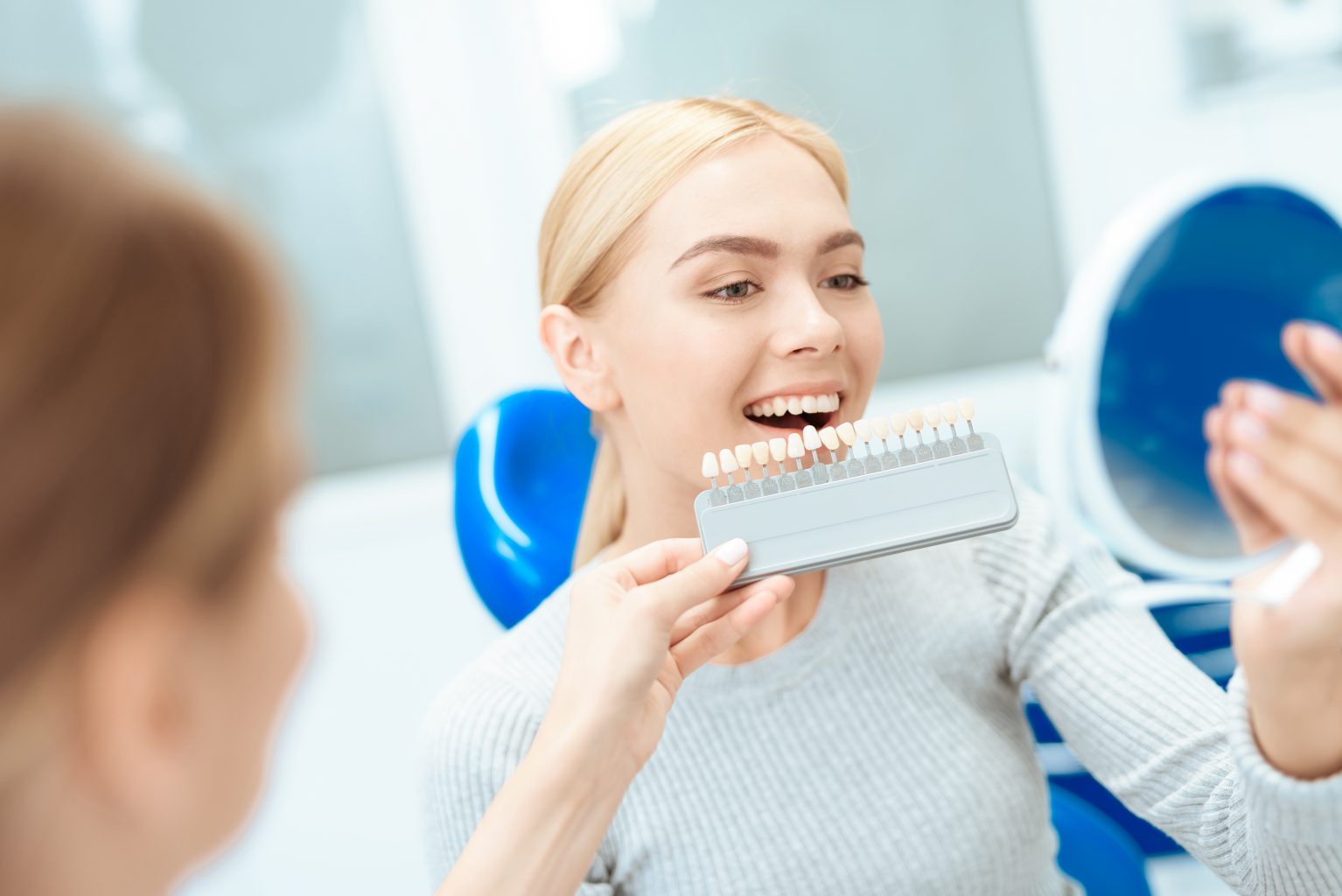 A Woman Came To See A Dentist For Teeth Whitening. The Dentist Determines The Color Of Her Teeth